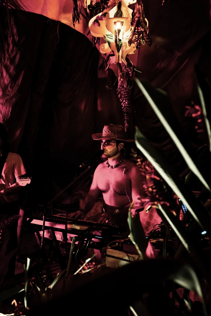 A DJ in a hat performing at night