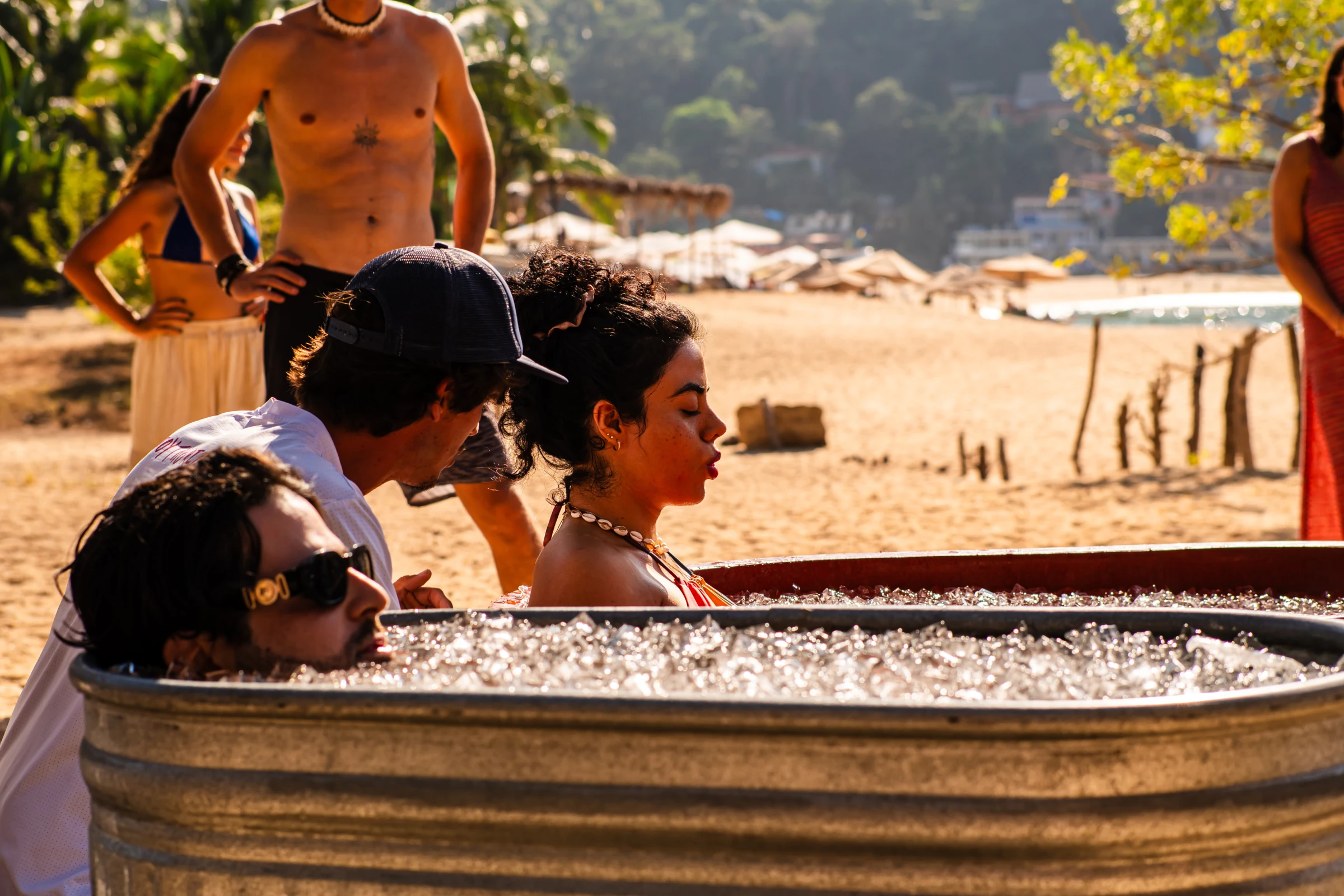 People gathered beside a beach DJ booth